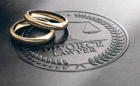 Book that says "Divorce Lawyer" with wedding bands on top of it