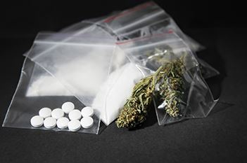 Drugs. Including, white pills, white powder, and marijuana in little plastic bags. Notably used for illegal drug dealing.