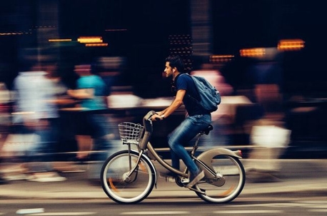 A man riding a bike in a busy city.