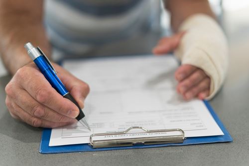 Injured man filing paperwork for personal injury claim with lawyer